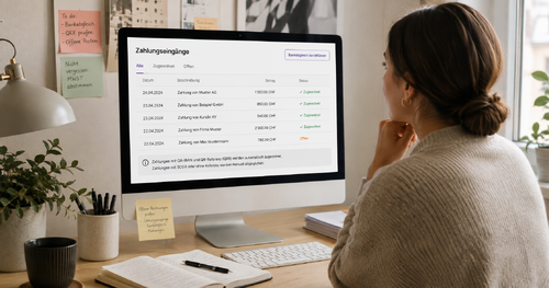 Eine Frau prüft Zahlungseingänge und offene Rechnungen am Computer.
