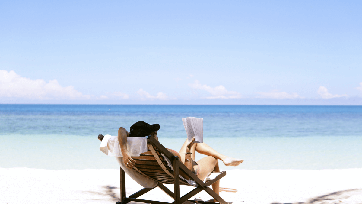 Frau in den Ferien liest Buch am Strand