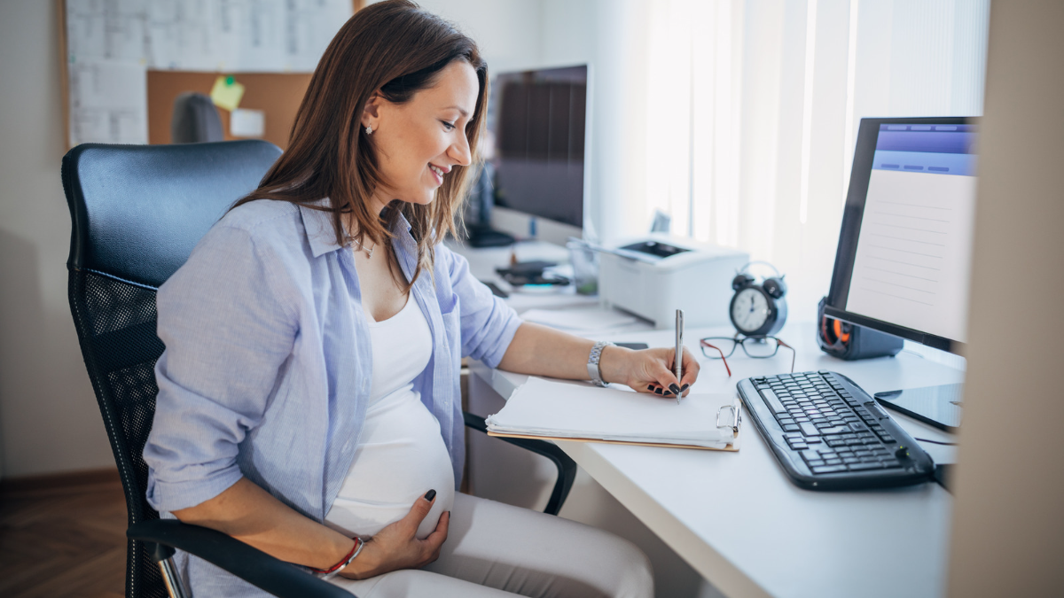 Schwangere Frau im Büro am arbeiten