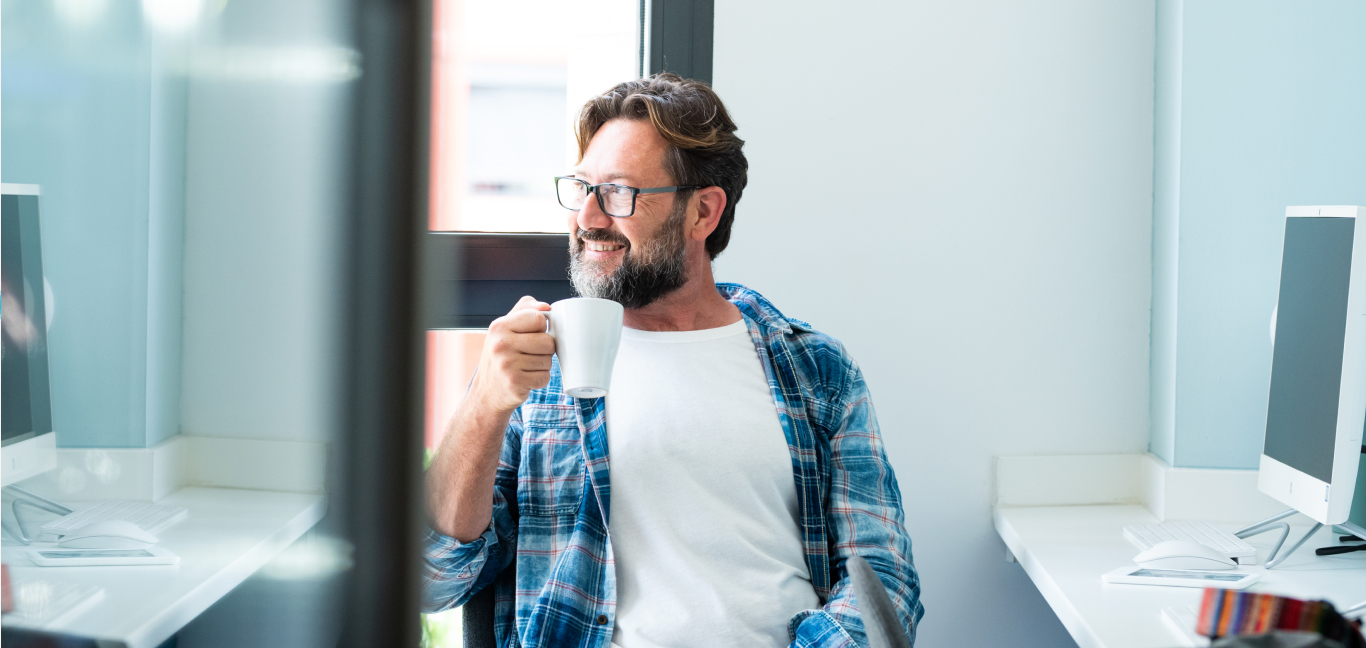 Mann zufrieden am Kaffee trinken nachdem er die Jahreslohnmeldungen eingereicht hat.